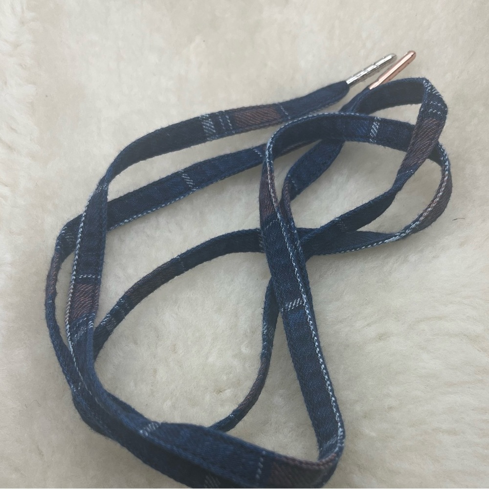 A pair of indigo plaid twill chow lace with mixed match tips